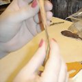 Continue forming the clay around the wire to create the shape of the dolls broom